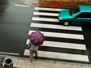 Pedestrian with an umbrella crossing in the Rain
