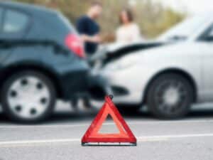 People discussing after a car crash and trying to find an agreement, main focus on red triangle
