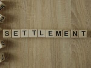 Settlement word from wooden blocks on desk