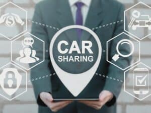 Car Sharing Business Concept. Automobile pooling cheap travel. Man offers tablet computer with location car sharing on virtual screen.