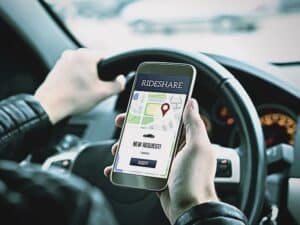 Ride share driver in car using the rideshare app in mobile phone
